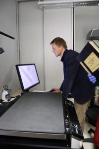 Andrzej Siwy skanuje materiały archiwalne w pracowni digitalizacji