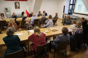 Muzealnicy siedzą w sali konferencyjnej archiwum